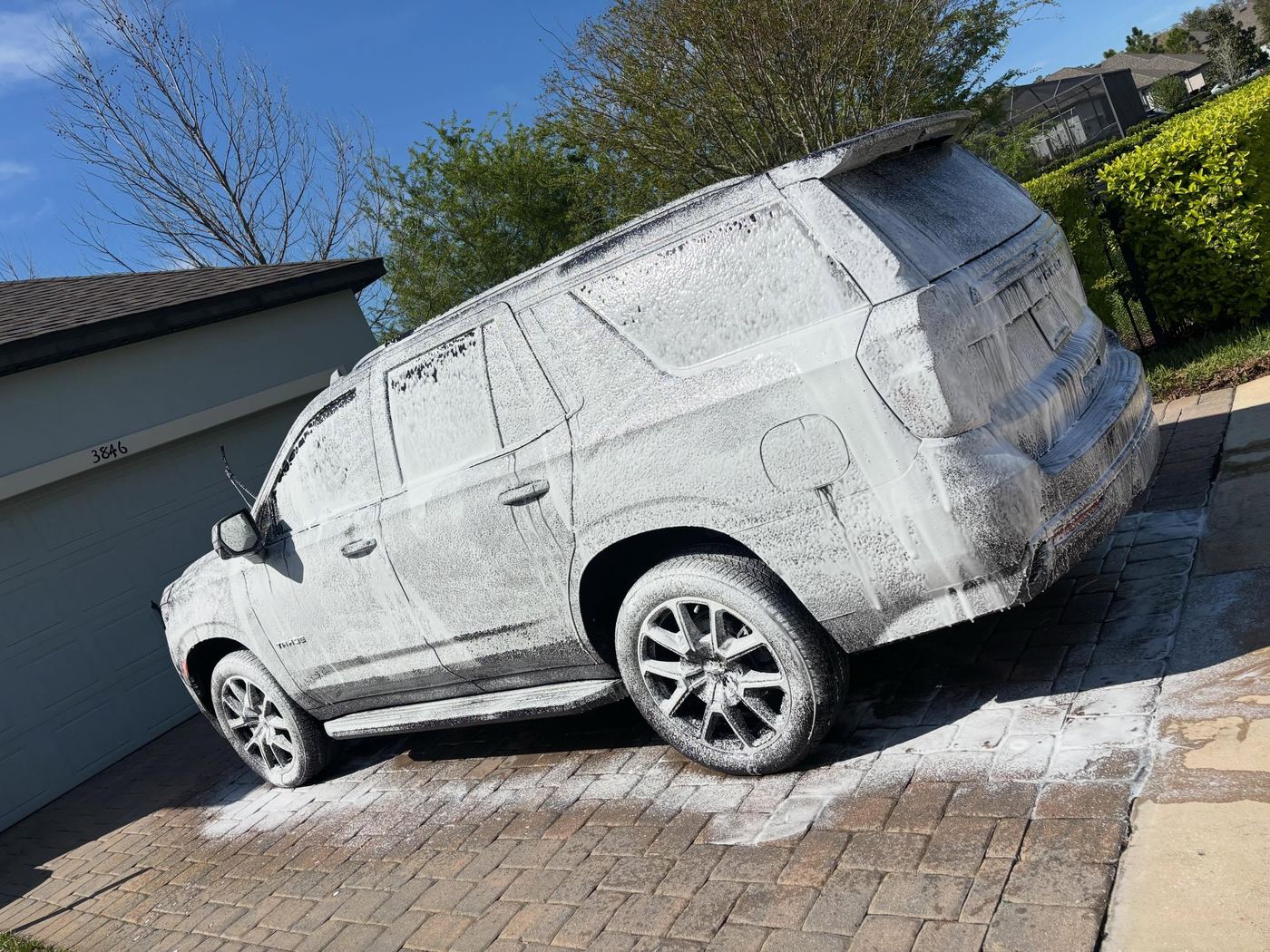 Black Chevy Tahoe mid foam bath during a Premier One detail in the 727